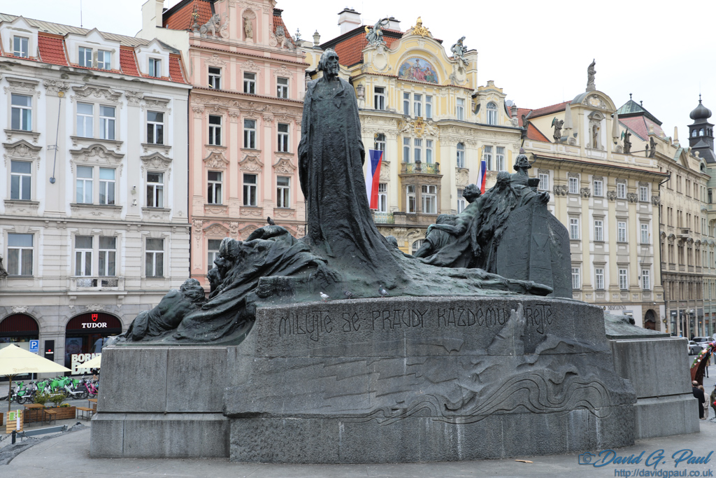 A stone monument of one person standing and others laying around him