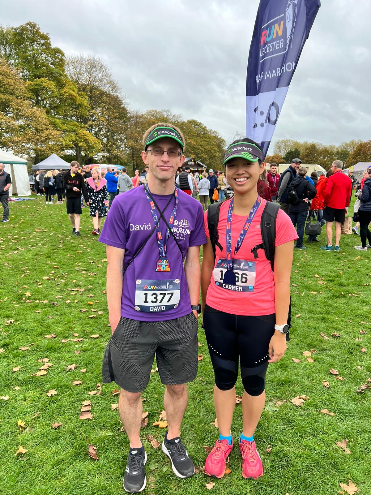 A male and female runner with finisher medals