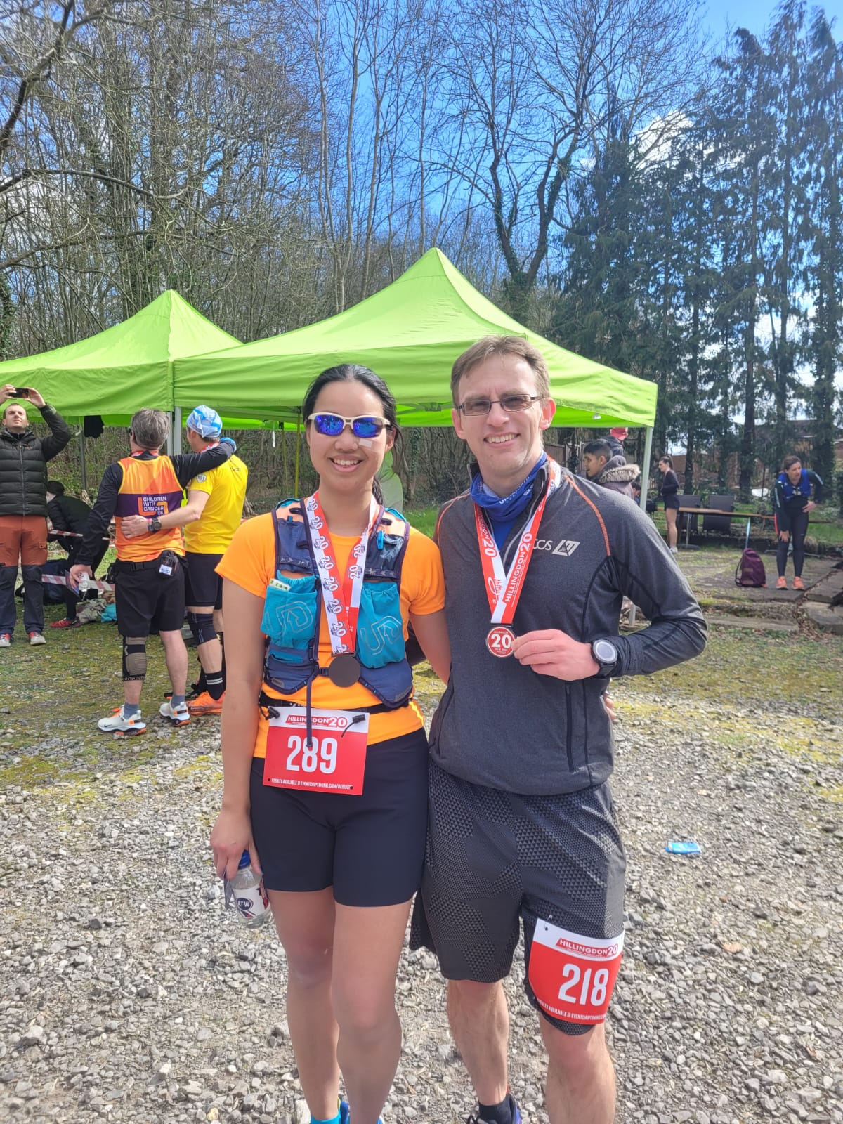 A male and female runner standing with their medals